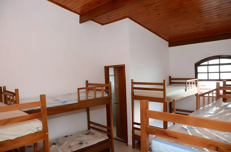 Suíte com forro de madeira, beliches e cama de solteiro